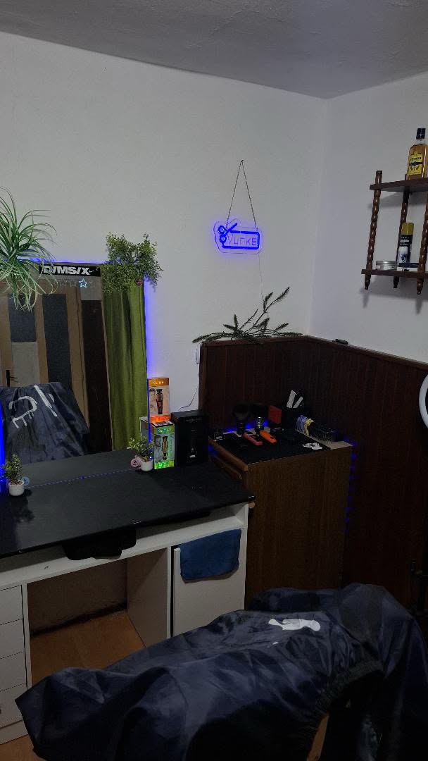 Vunke Cuts — enterijer salona sa neonskim znakom